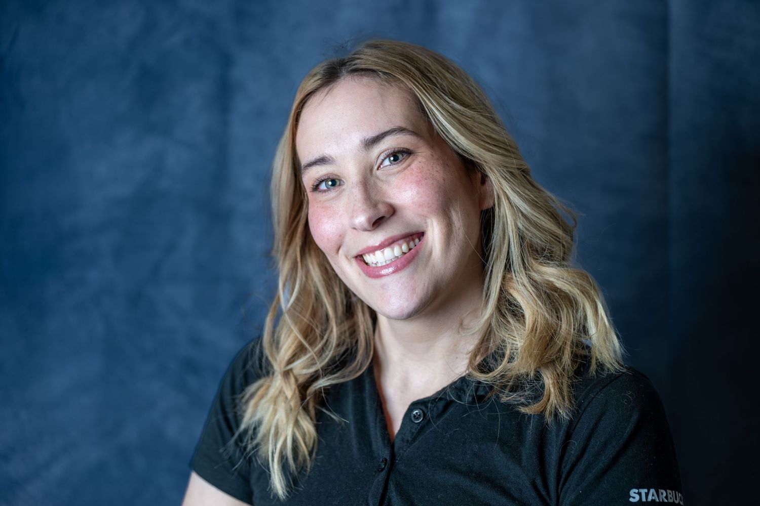 Stylish studio portraits with person in black outfit against blue background.