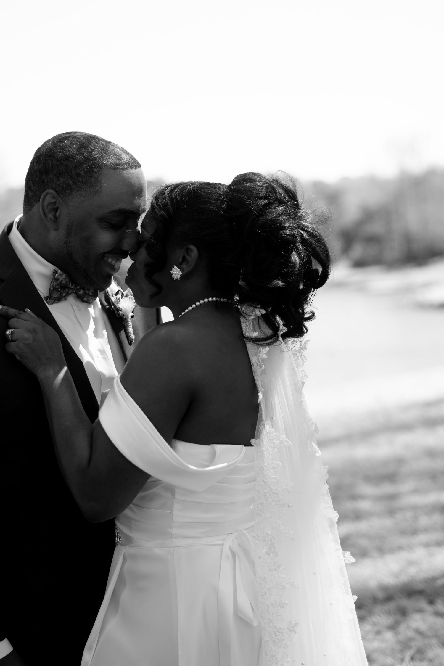 Romantic black and white wedding photo showing intimate moment between newlyweds.