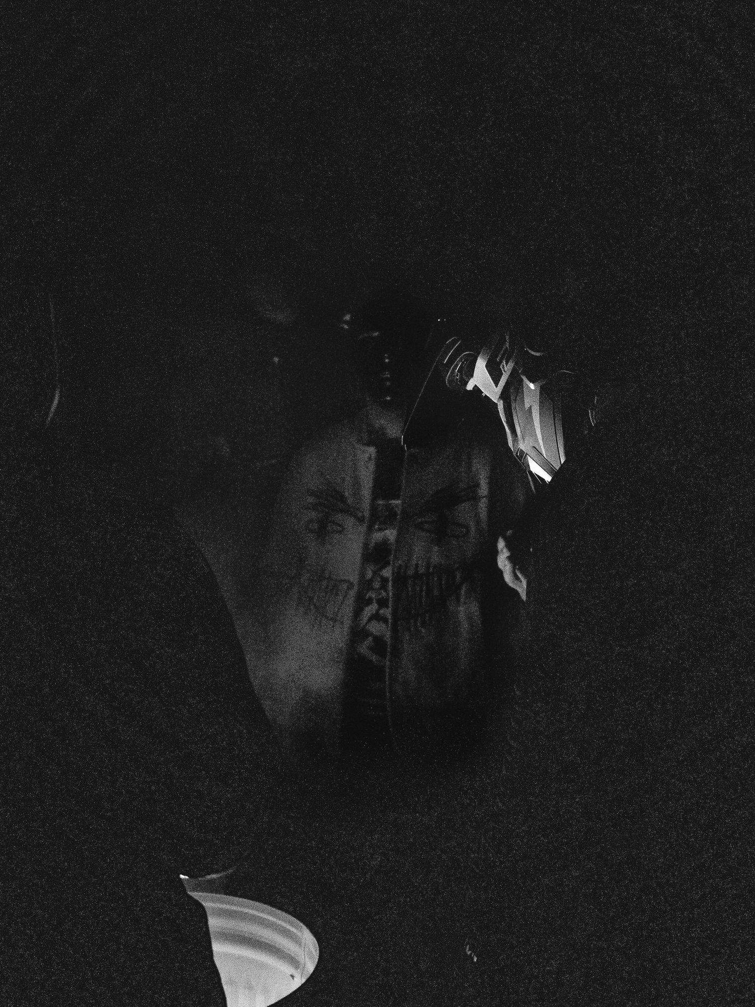 Moody black and white artistic photograph showing a shadowy figure in dark lighting with dramatic contrast.
