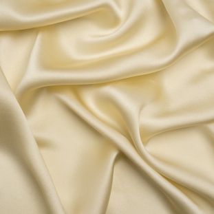 Elegant cream colored silk fabric with soft folds and waves.