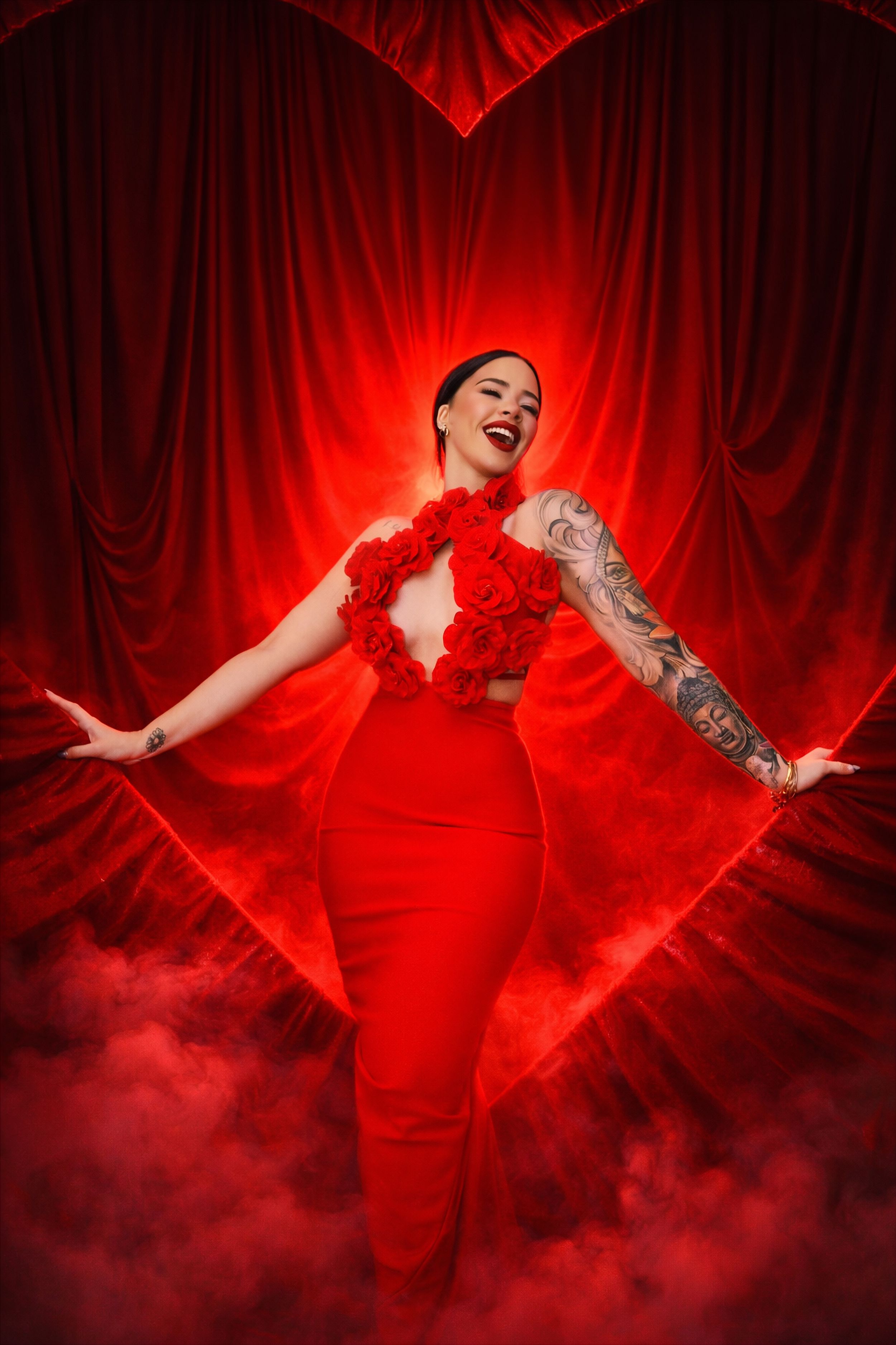 A figure in a flowing red dress dances dramatically against red curtains with theatrical smoke effects creating a mystical atmosphere.