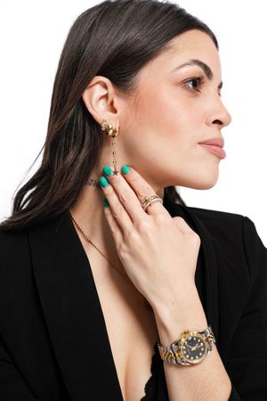 Model wearing elegant gold and turquoise jewelry showcases earrings and bracelet against black blazer in profile poses.