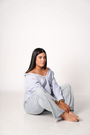 Model in casual gray loungewear poses on white background in minimalist fashion photoshoot series.
