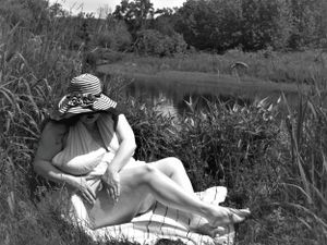 Monochrome photograph capturing a restful moment in nature with flowing white fabric.