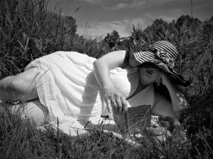 Ethereal black and white photograph showing person in flowing dress amid natural landscape.