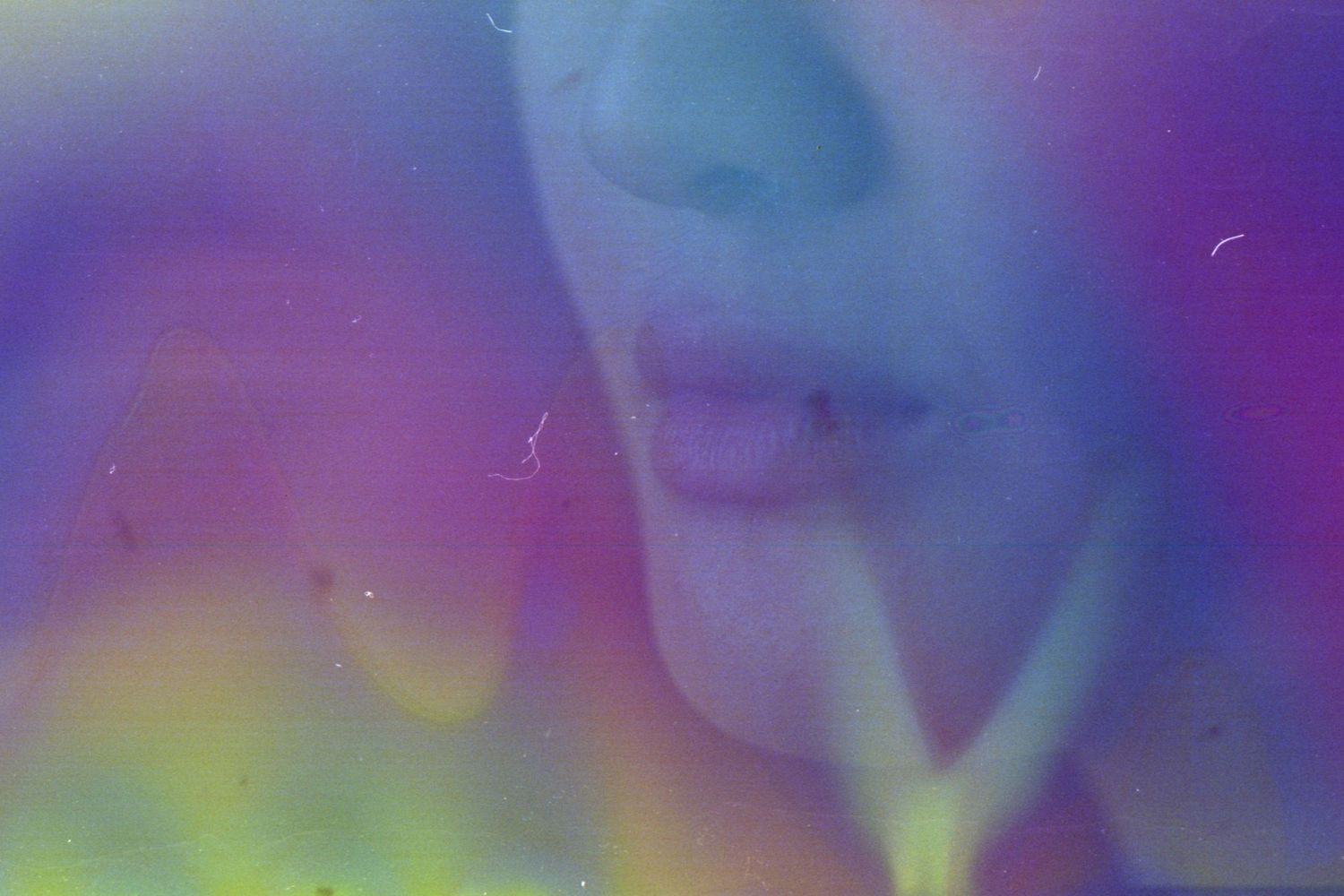 Abstract artistic portrait with vibrant rainbow colors and soft blurred details creating a dreamy effect.