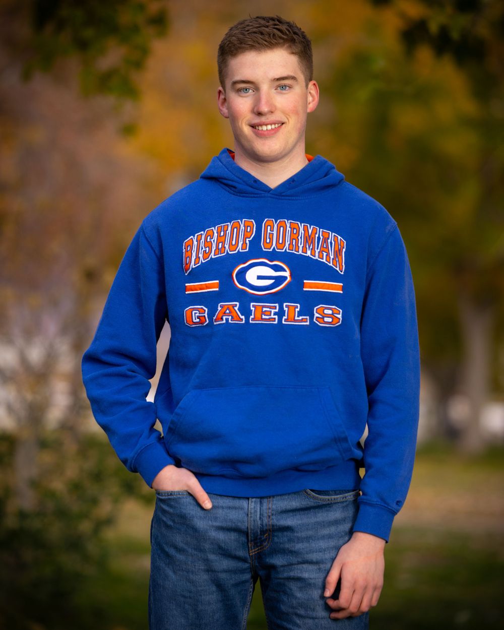 Athletic portrait showing Bishop Connor Gaels blue school spirit hoodie against fall foliage.