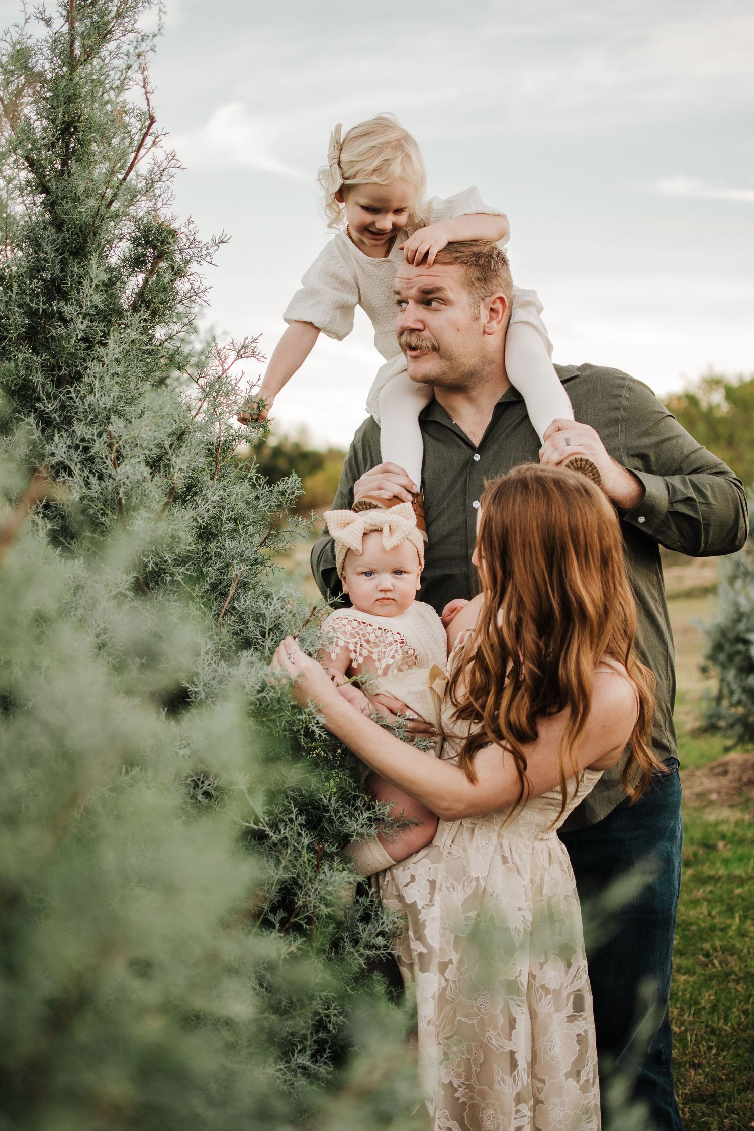 Dfw Tree Farm A candid family photoshoot outdoors with playful interactions among loved ones in a natural setting.
