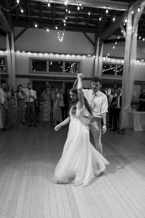 Black and white sequence shows a couple dancing at their wedding reception on a hardwood dance floor.