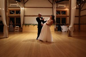 Panoramic view of an empty wooden floor dance studio with large windows and natural lighting.