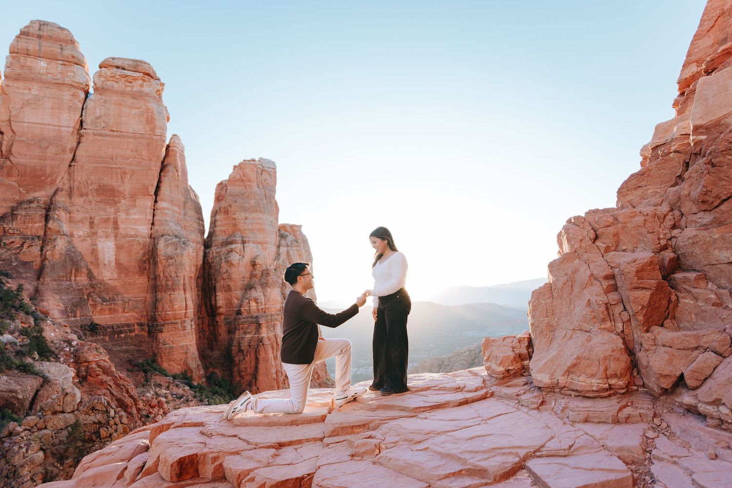 Panoramic view of a proposal moment set against towering red rock formations in the desert.