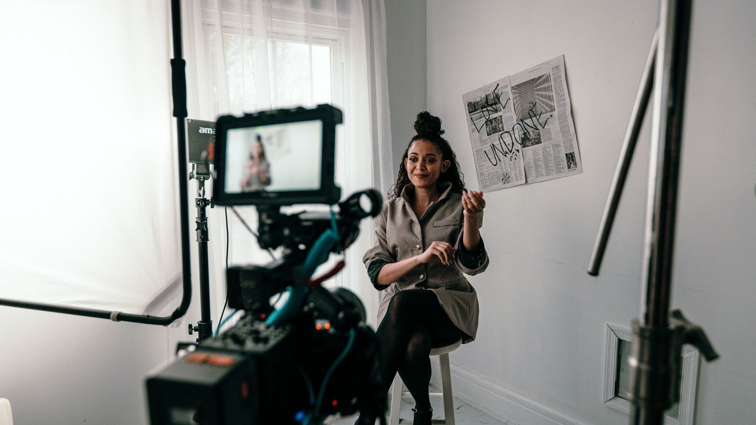 Three black and white film photographs showing a person alone in an indoor setting with camera equipment.