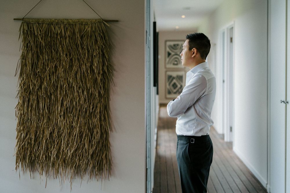A decorative woven wall hanging made of natural fibers displayed in a minimalist hallway.
