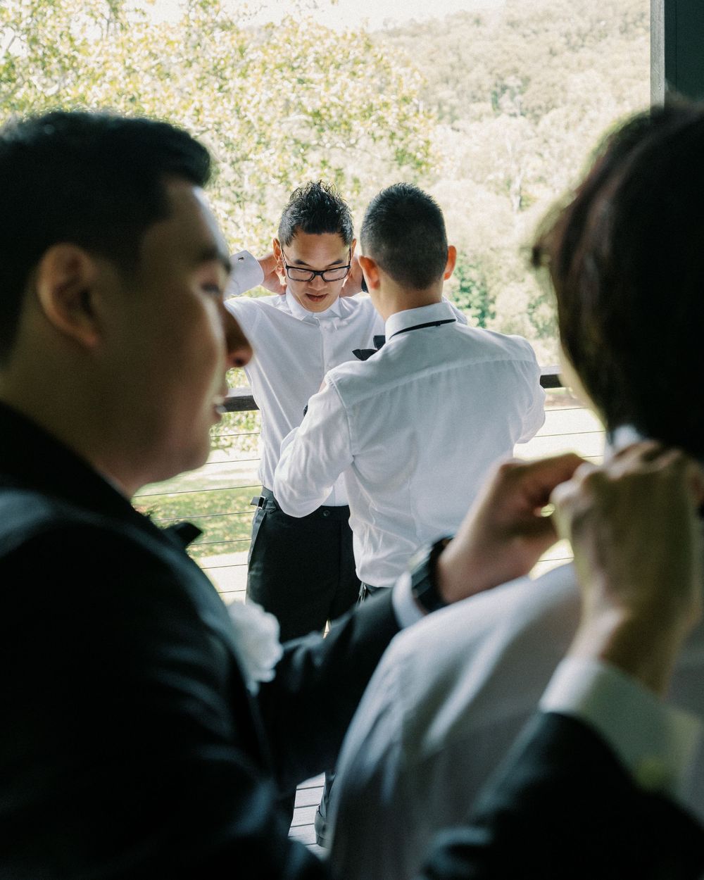 A casual gathering outdoors with people in white shirts enjoying conversation in natural sunlight.