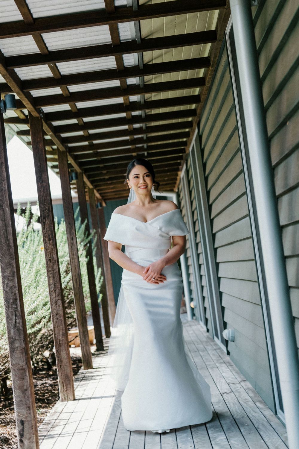 Wedding dress photos in a covered walkway with architectural columns.