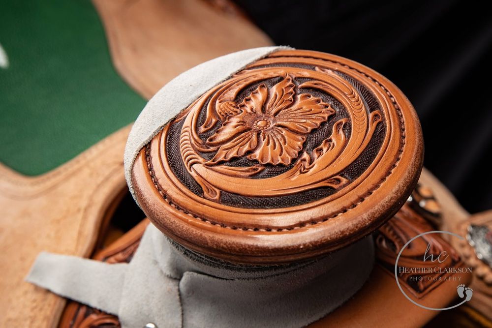 Detailed view of ornate wooden coasters with carved floral designs and intricate patterns set on a dark surface.