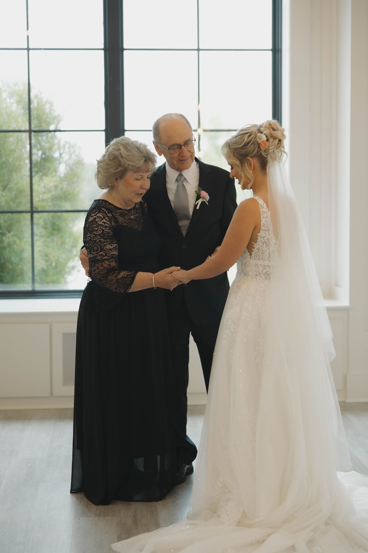 A series of four wedding dress preparation photos showing a gown being carefully adjusted in a bright sunlit room.