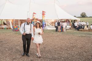 Wedding guests enjoying outdoor games and activities on a sunny day in a countryside setting.