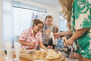 Wedding guests enjoy a casual meal with donuts and refreshments at decorated tables.