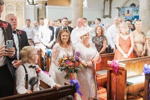 Vibrant wedding ceremony in traditional church with colorful floral bouquet.