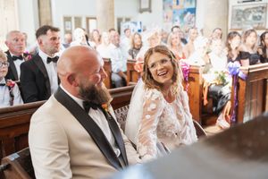 Joyous celebration inside church with stained glass windows and smiling guests.
