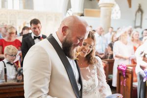 A touching ceremony moment between participants in a beautifully lit church interior.