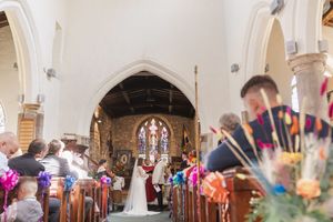 Church wedding ceremony with decorative bunting and floral arrangements adorning the aisle.