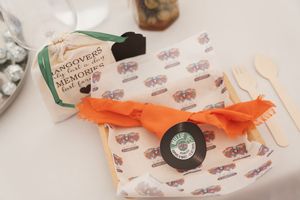 A rustic wrapped gift with orange ribbon and decorative paper featuring a small tag.