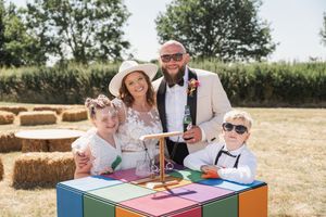 Wedding reception guests seated at outdoor tables enjoying a celebration in a rustic setting.