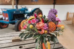 A vibrant floral arrangement with pink and purple blooms displayed on a wooden table.