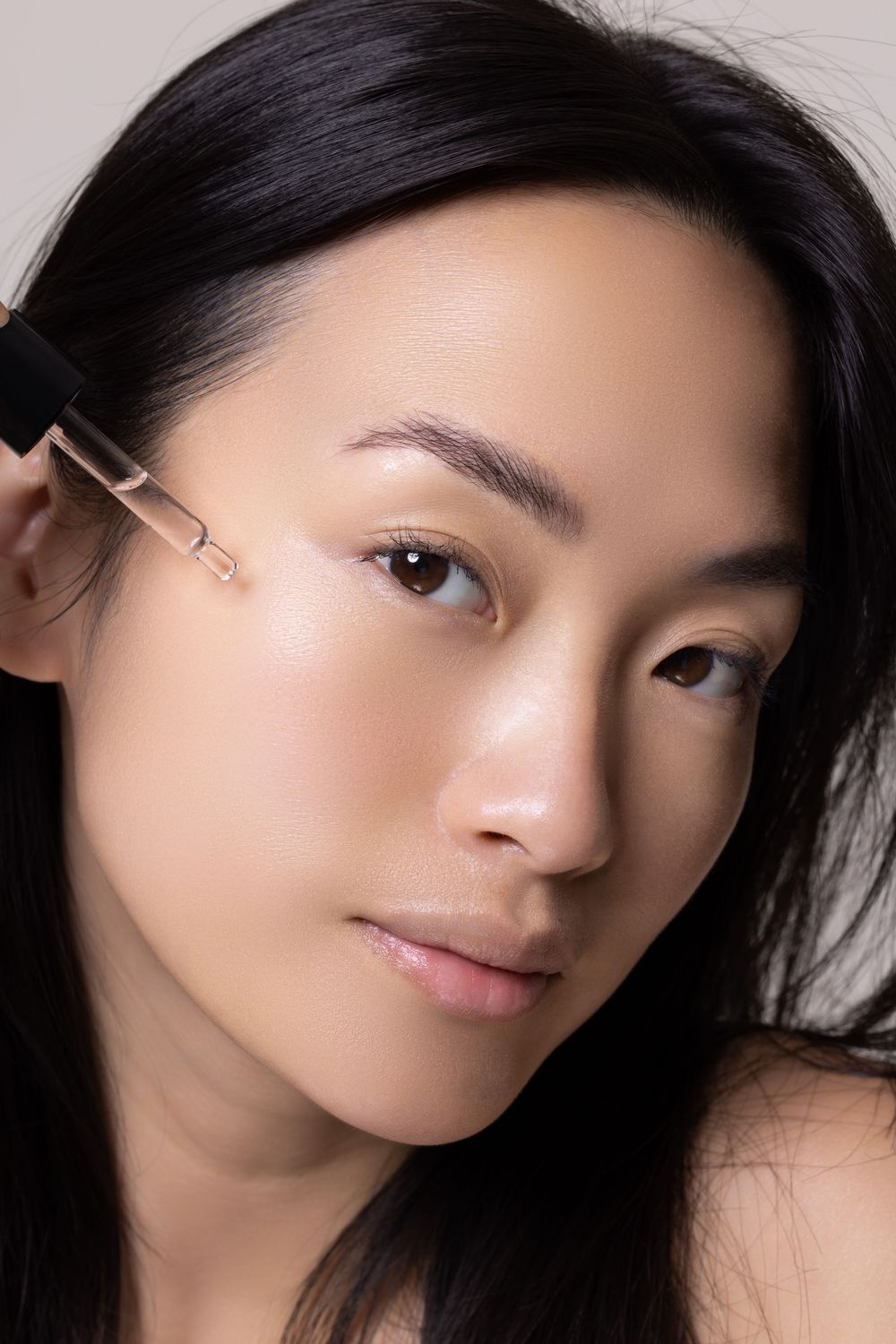 Close-up beauty portrait showing natural glowing skin and dark hair.