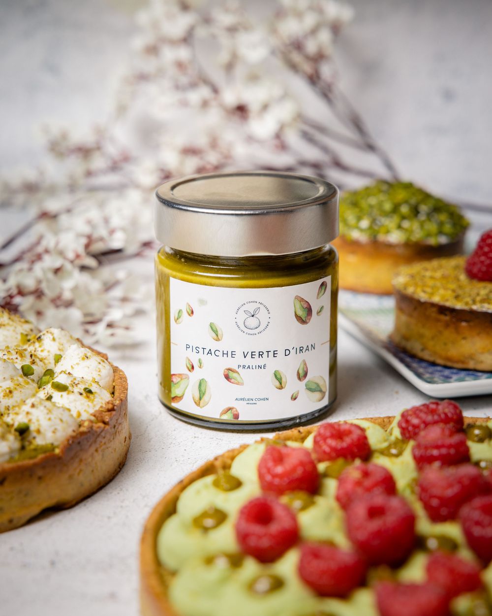 Artisanal pastries and fresh raspberries arranged with decorative tin containers.