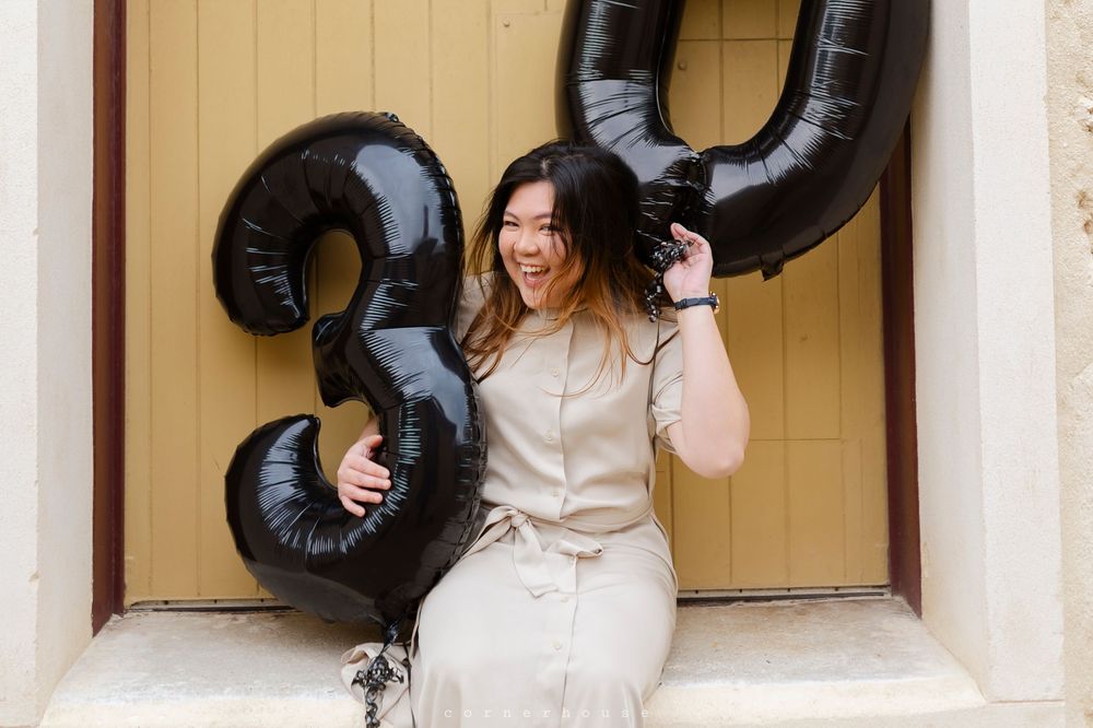 Four festive photos with balloon letters spell out XOXO against a beige wall backdrop.