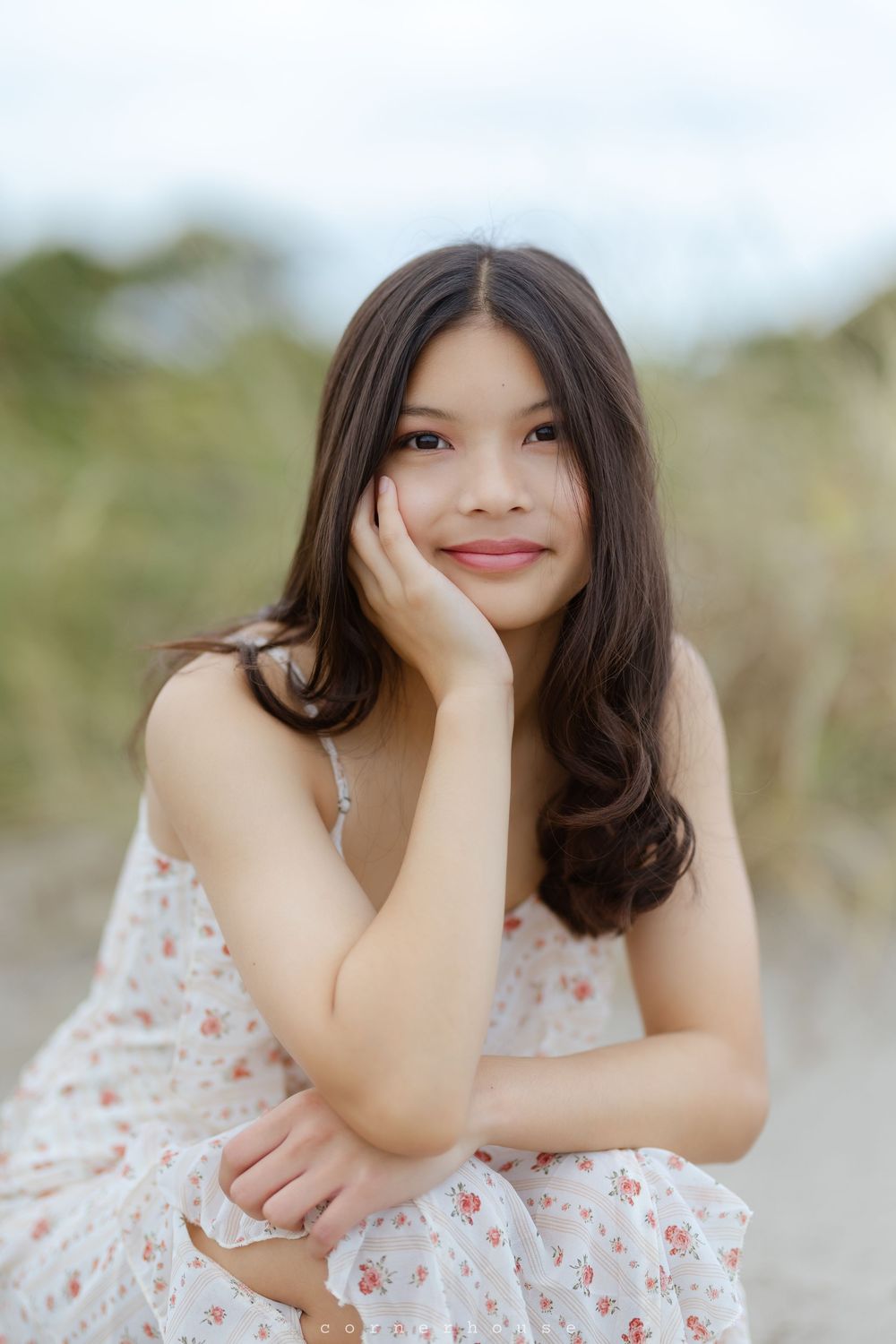 A dreamy portrait series showing someone wearing a white floral dress while posing casually outdoors.