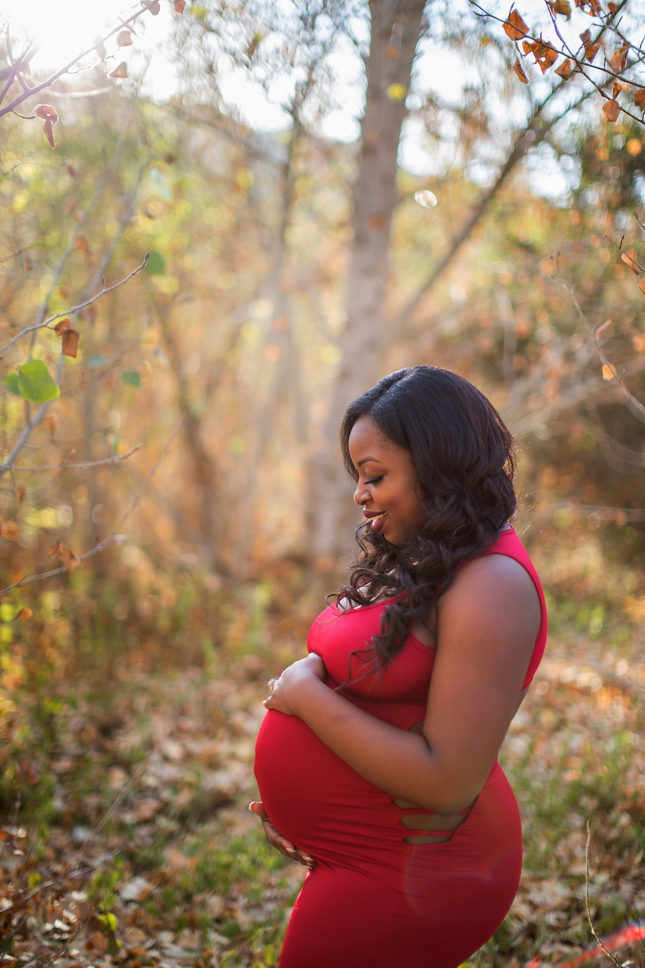 An autumn maternity session captures intimate moments among fall foliage.