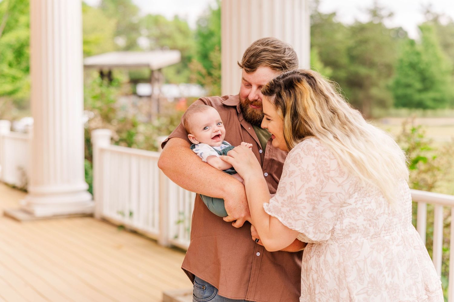 A tender family moment shared on a white columned porch during golden hour.