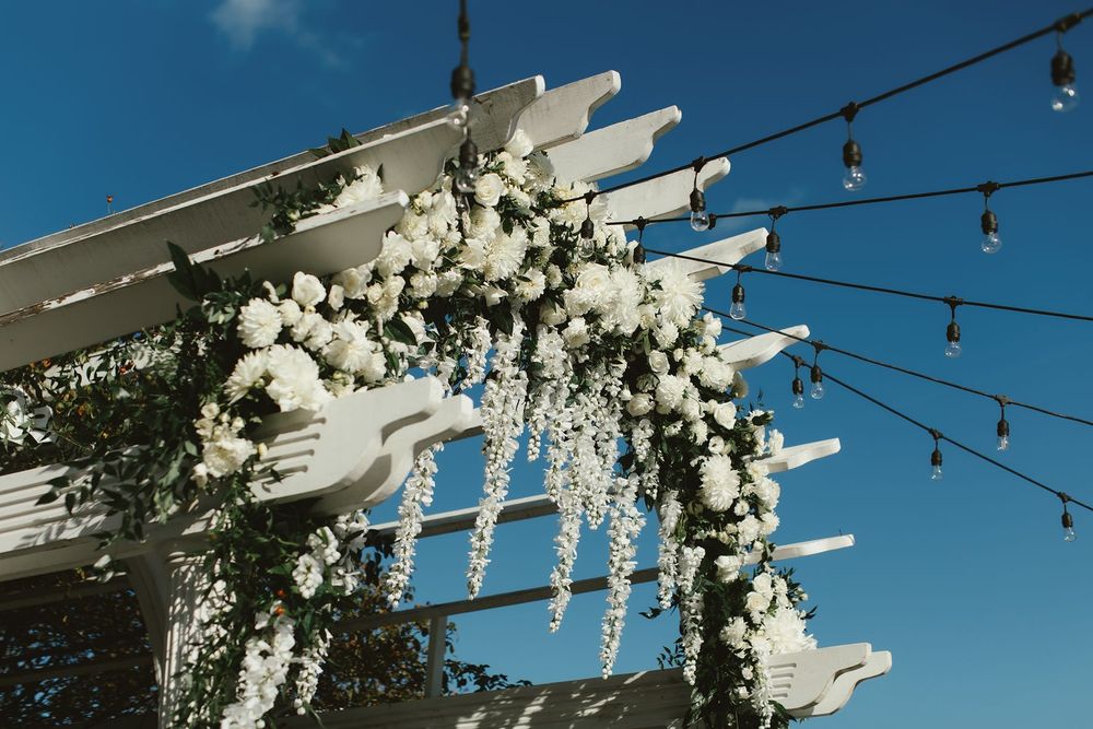 Ceremony arbor with white flowers at The Vineyards at Aquebogue