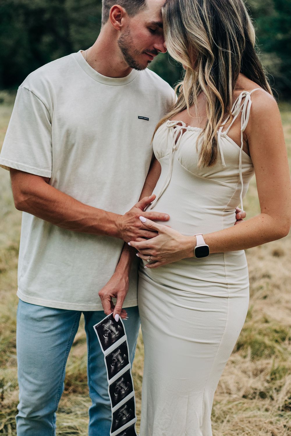 pregnant couple hold ultrasound photos
