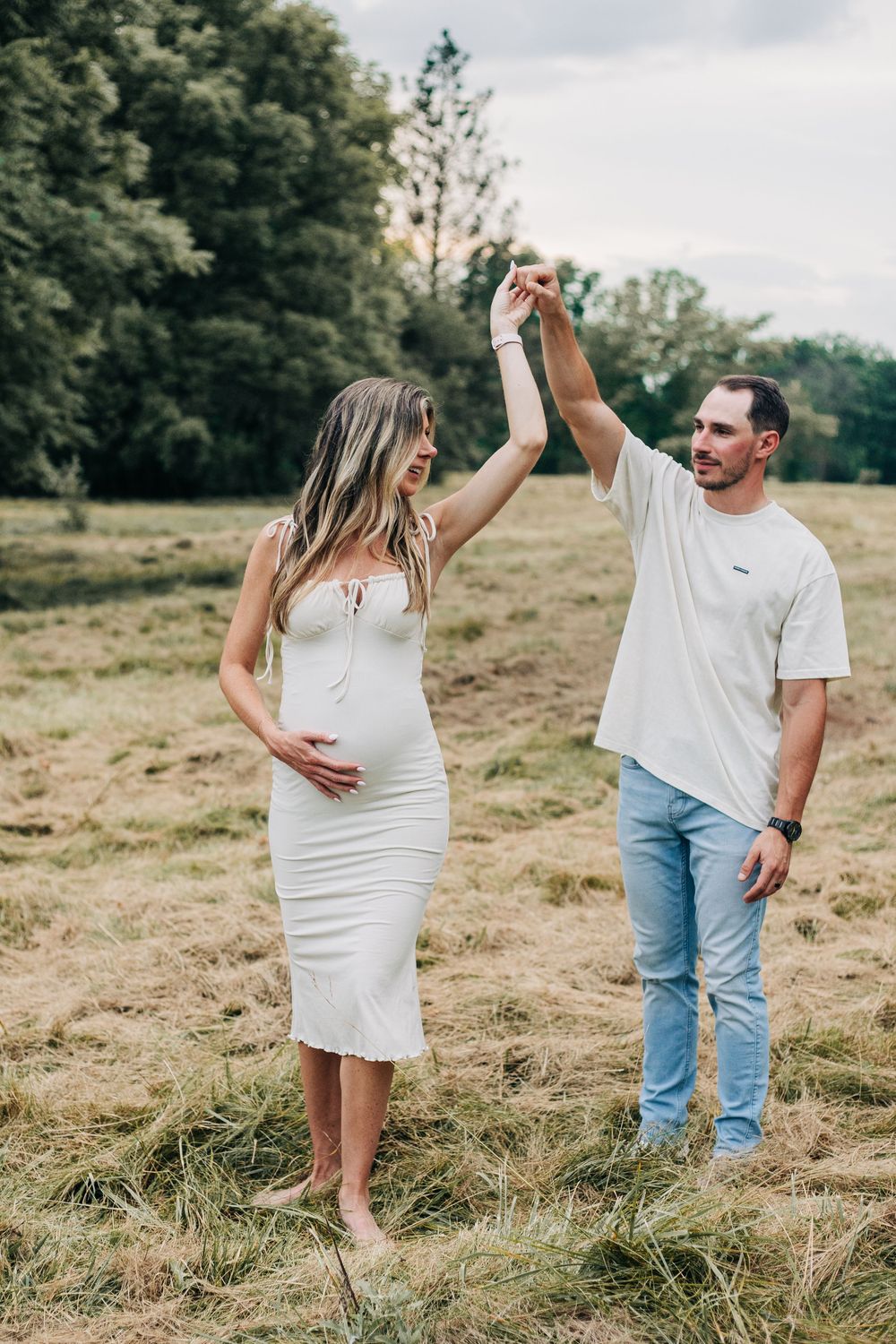 pregnant couple spin in field