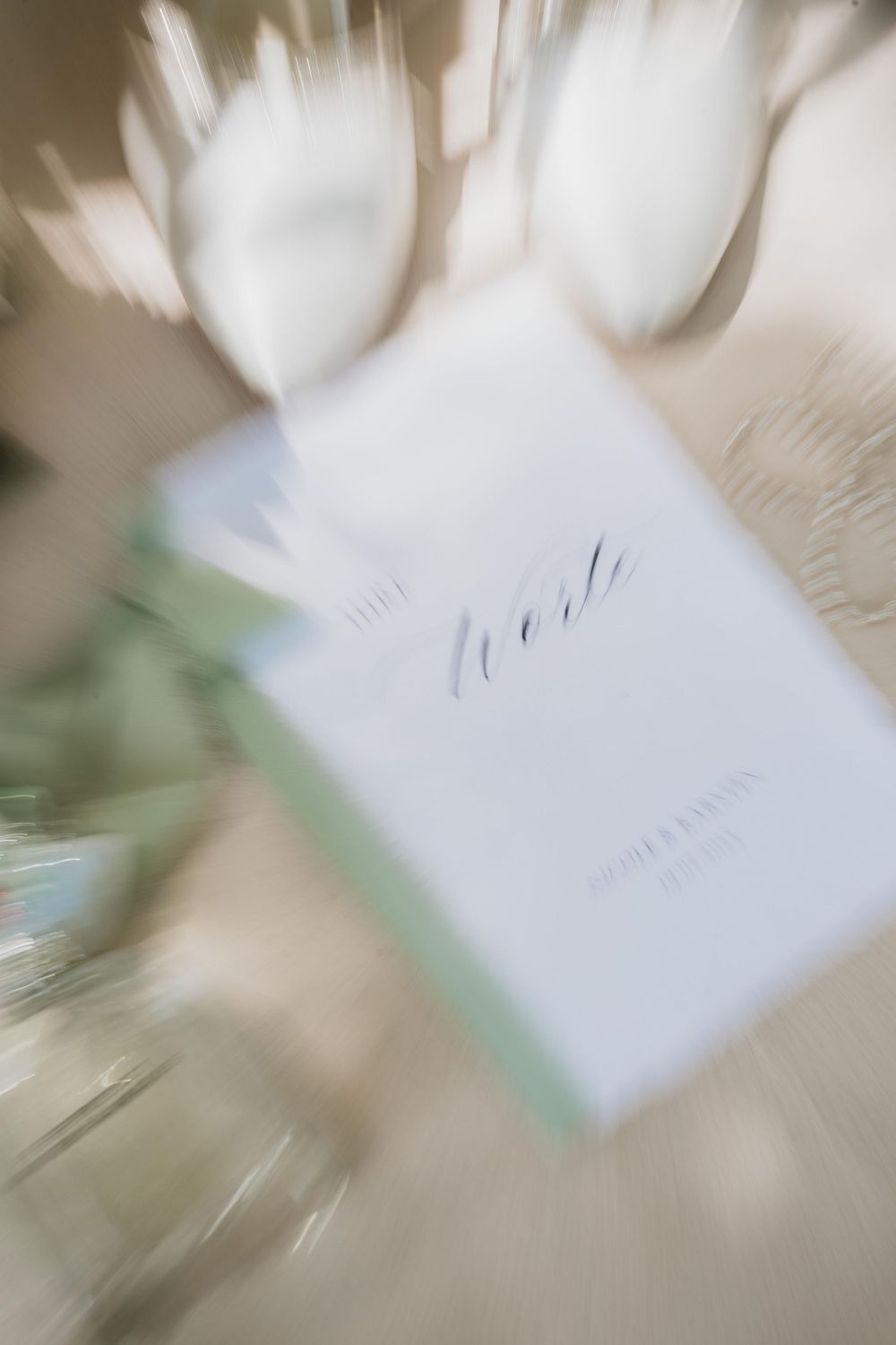 Artistic blurred motion shot of a white wedding invitation card.
