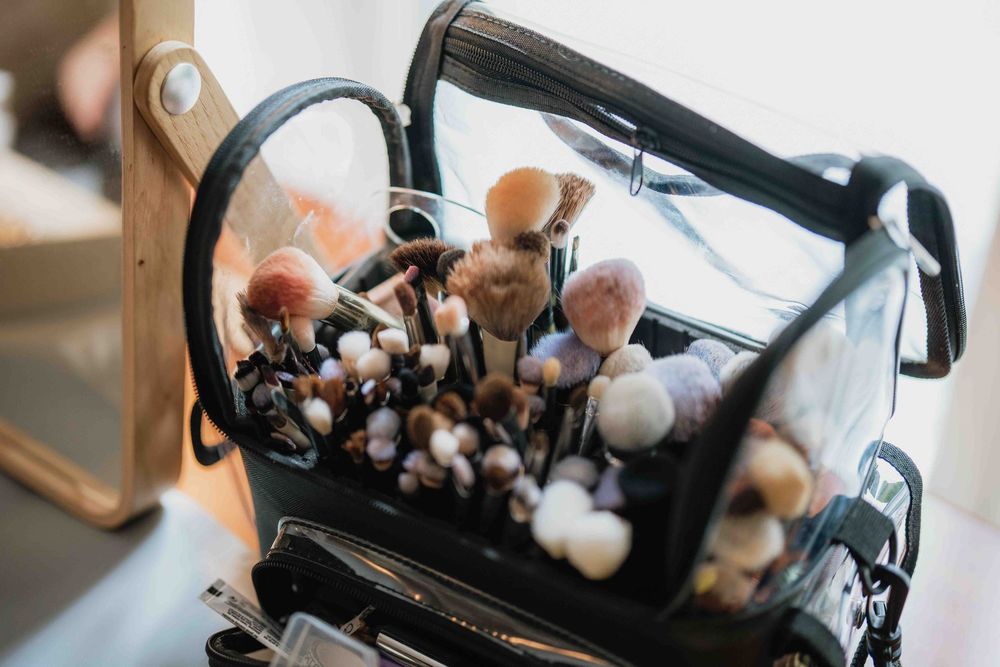 Makeup brushes stored in a clear plastic organizer case.