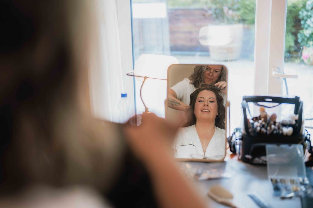 Wedding makeup preparation scene with professional equipment and mirror.