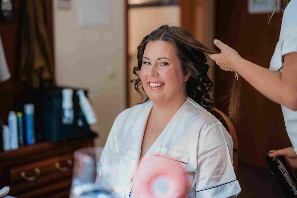 Bride and wedding party members get ready in white robes before the ceremony.