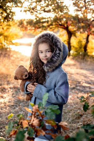 Autumn sunset portrait session with warm golden light filtering through trees.