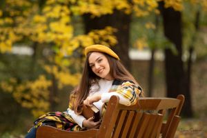 Autumn portrait series with wooden chair and falling yellow leaves.
