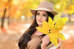 Fall photography featuring brown hat and bright yellow maple leaves.