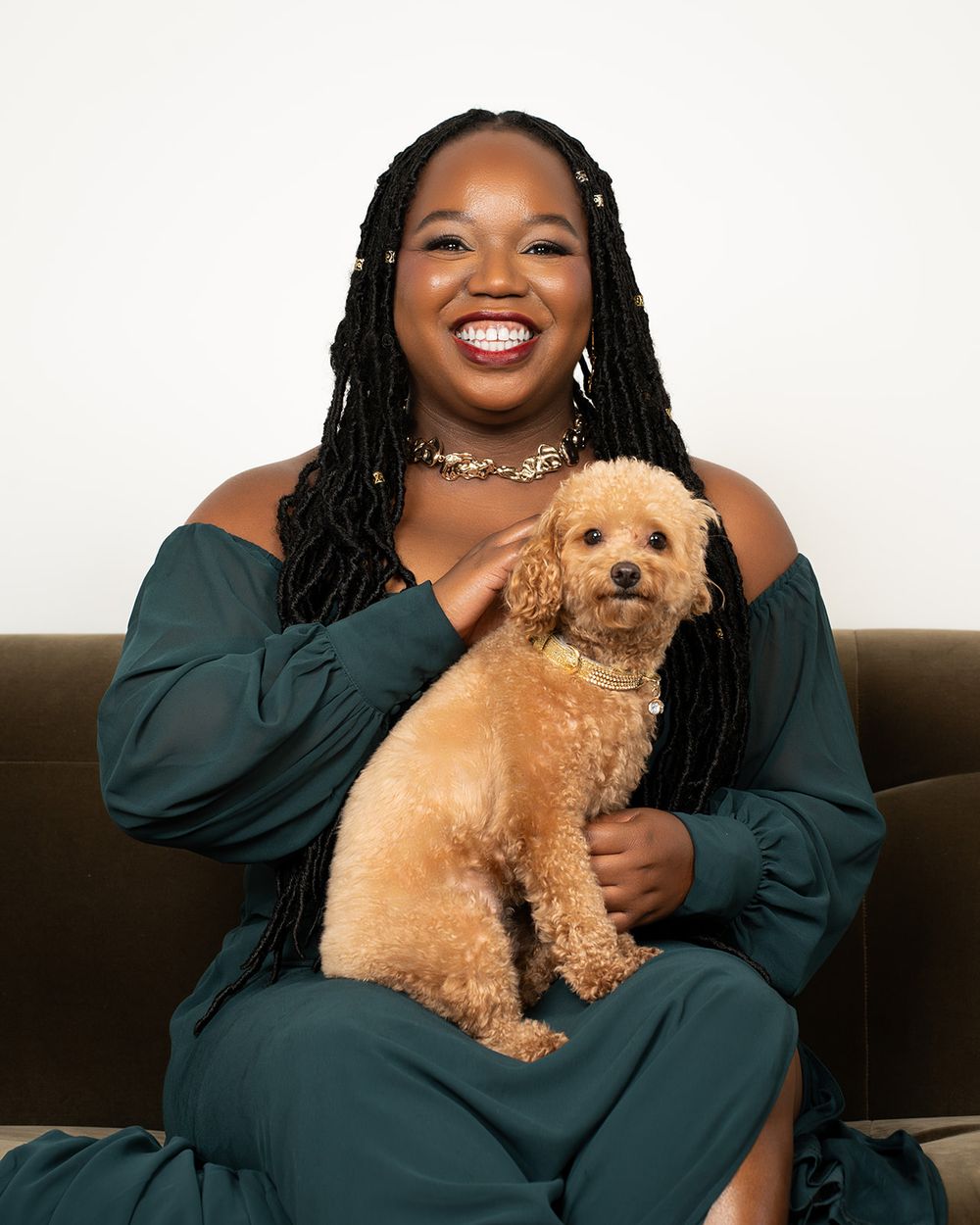 Joyful portrait session with a fluffy goldendoodle puppy on a dark couch.