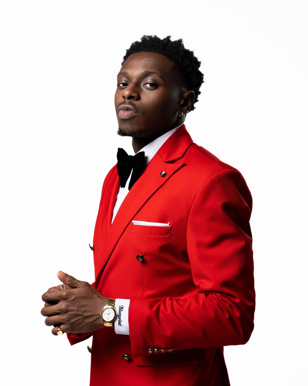 Professional poses in bright red suit jacket with white pocket square.