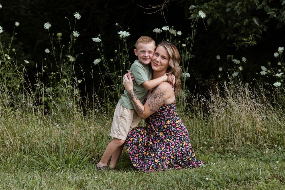 A tender embrace shared in a field of white wildflowers.