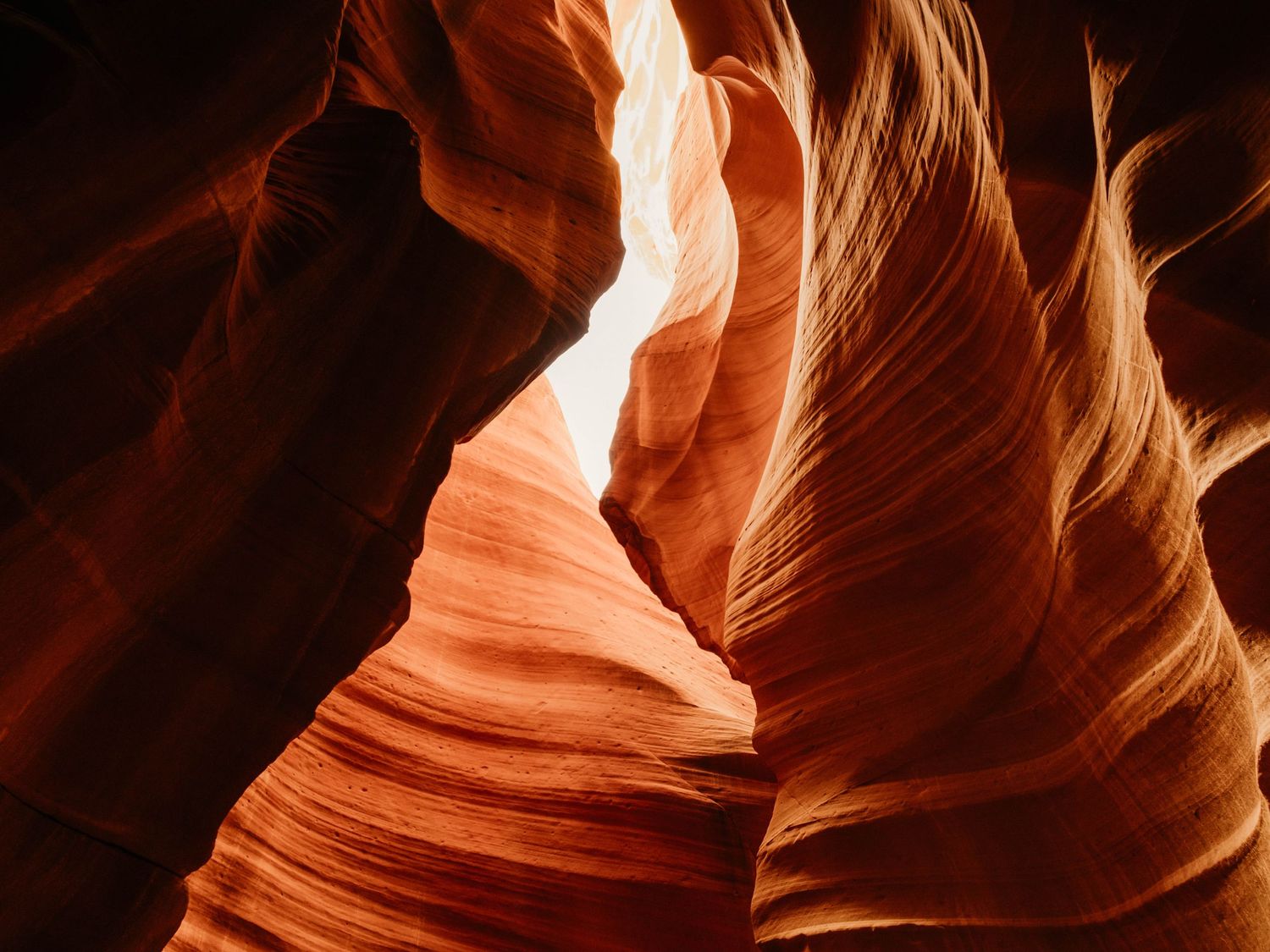 Sunlit sandstone formations creating dramatic curves in Antelope Canyon.